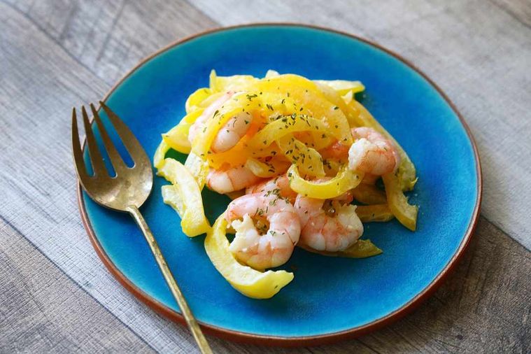 ターコイズブルーのお皿に盛られたえびと黄色パプリカの和え物