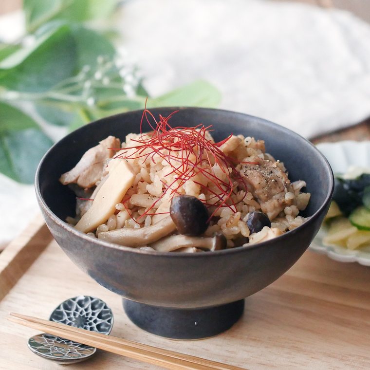 黒色の器に盛られた鶏肉ときのこ炊き込みごはん