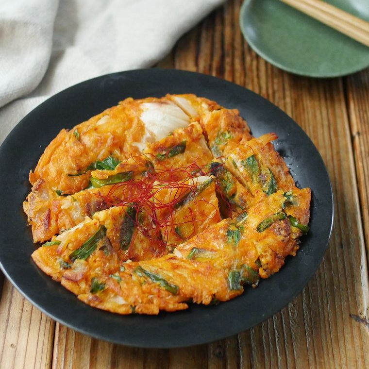 黒い皿に盛られたキムチチヂミ