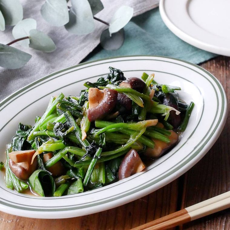 白とグリーンの皿にのったほうれん草としいたけのバターしょうゆ炒め