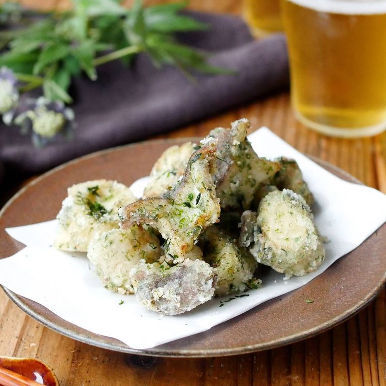 丸い皿に盛りつけられた無限のり塩エリンギとビール