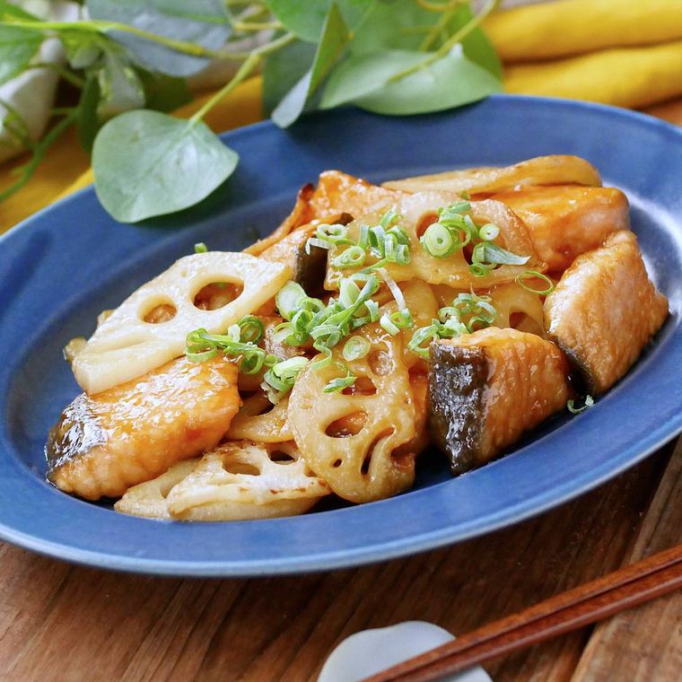 青い皿に盛りつけられたれんこんと鮭の甘酢炒め