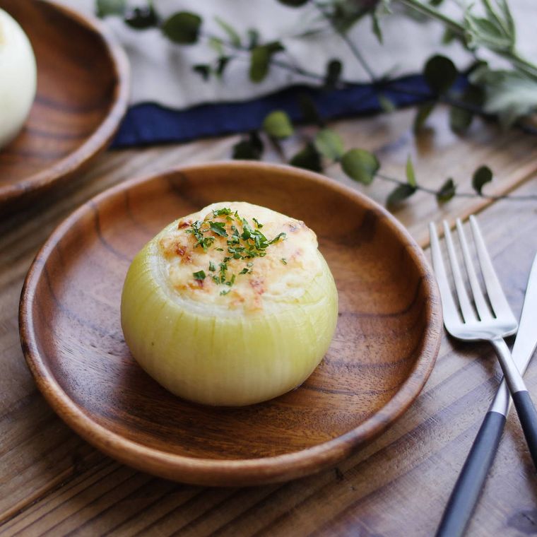 木製の皿に盛られたまるごと玉ねぎの肉みそグラタン