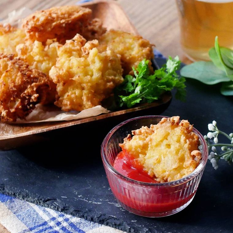 紙を敷いた木製の皿に盛られたオニオンナゲット