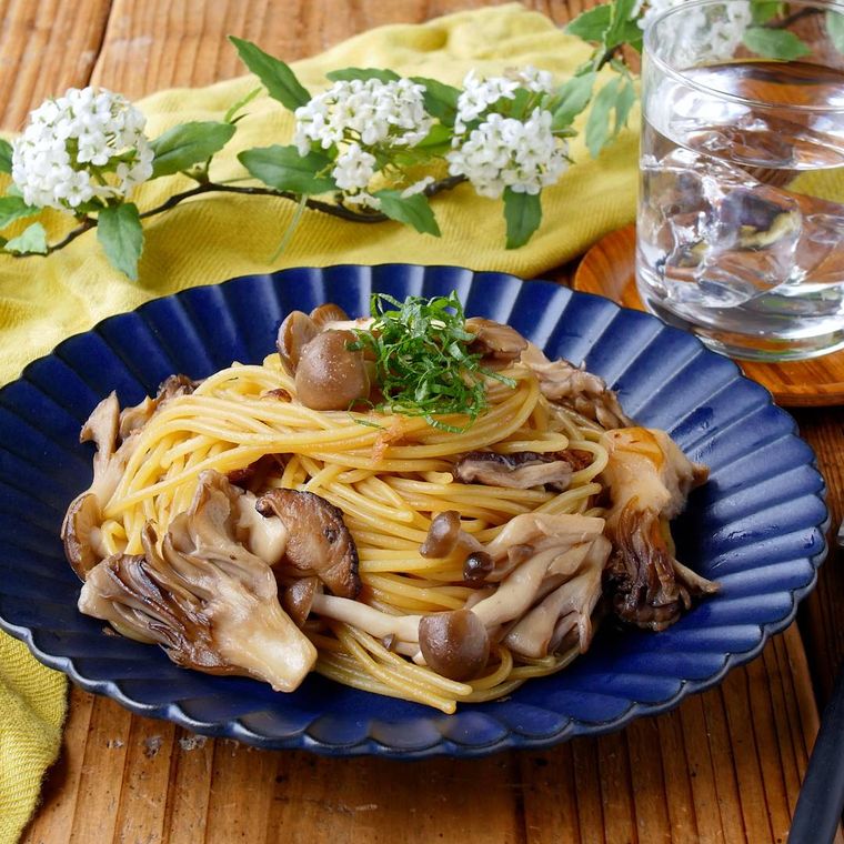 青い皿に盛られたきのこのバターしょうゆパスタ
