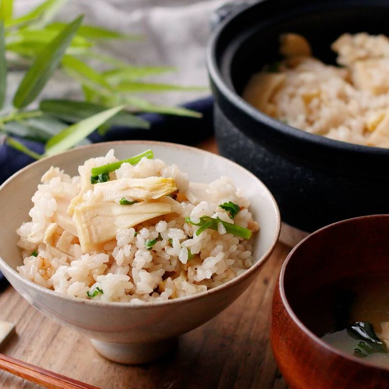 土鍋で炊いたたけのこごはんが茶碗に盛り付けられているところ