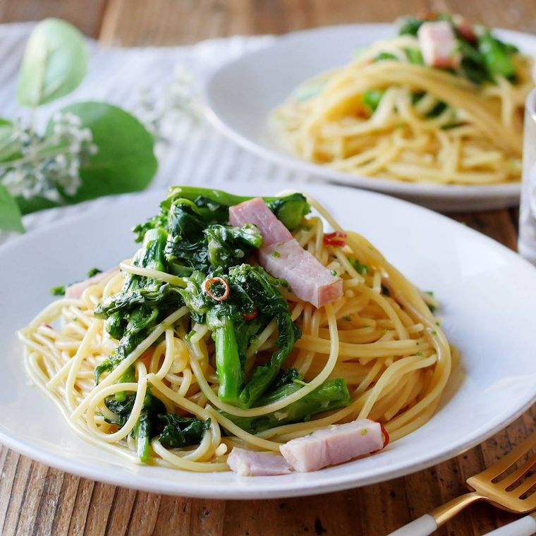 白色の丸皿に盛られた菜の花とベーコンのバターしょうゆパスタ