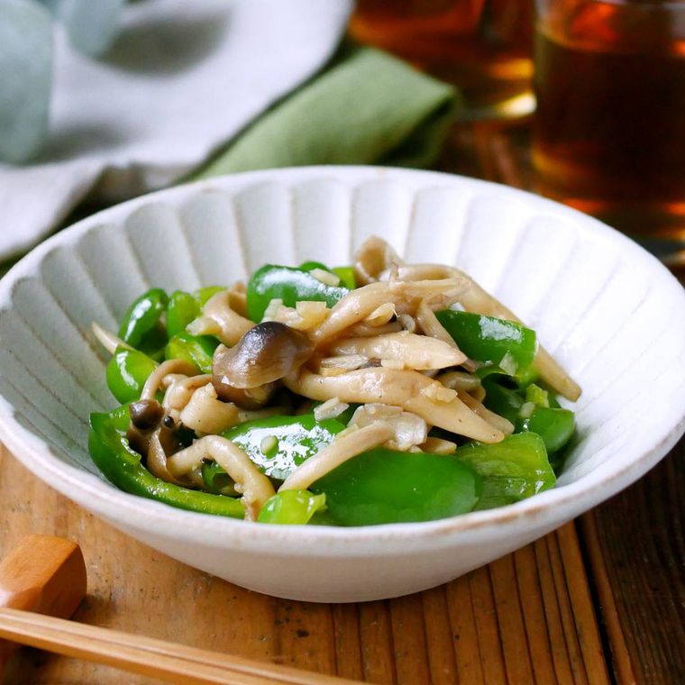 白い皿に盛られたピーマンとしめじの炒め物