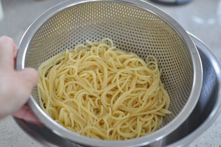 ザルでパスタの水気を切る様子