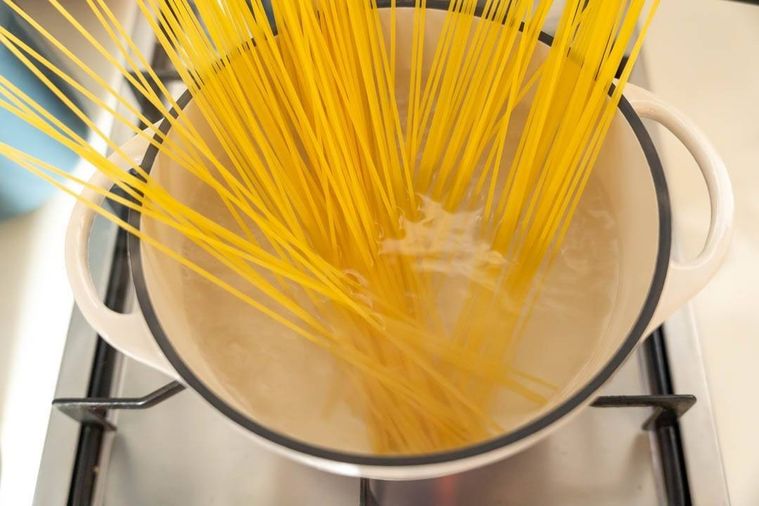 鍋にパスタを入れている