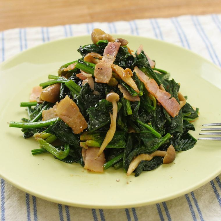 薄緑色の皿に盛り付けたほうれん草としめじの炒め物