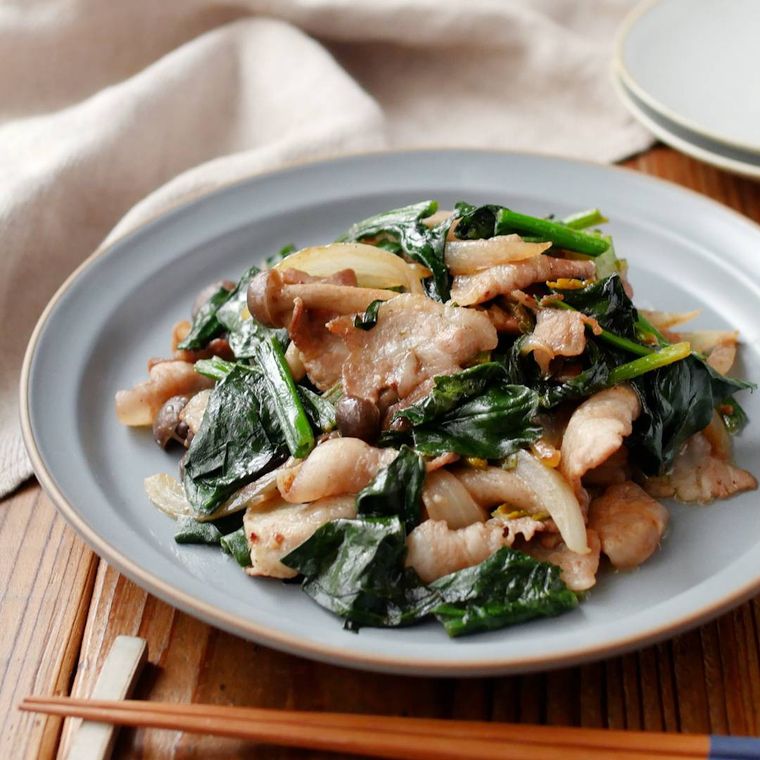 水色の皿に盛りつけられたほうれん草と豚肉のマヨポン炒め