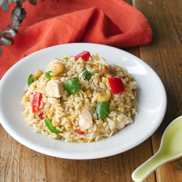 白い皿に盛り付けられた鶏肉とカシューナッツのチャーハン