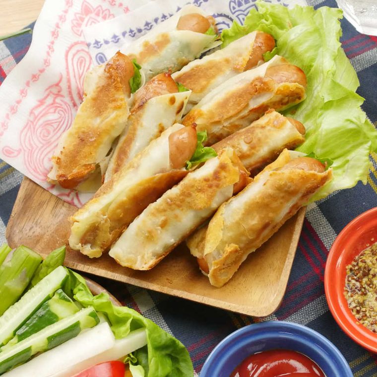 木の角皿に盛られた、ウィンナーとチーズのスティック餃子