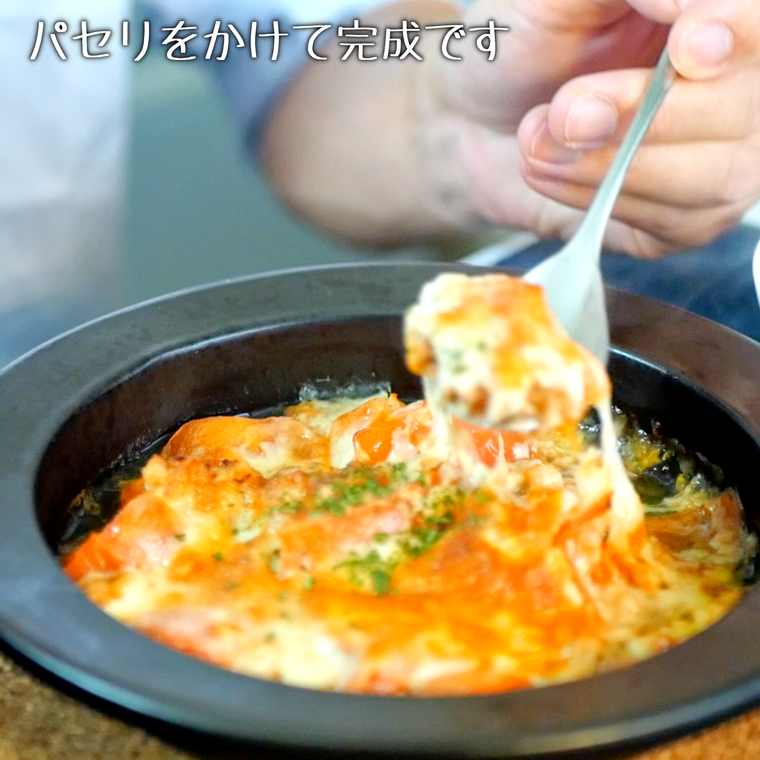 黒い皿に盛りつけられたトマトとツナのチーズ焼き