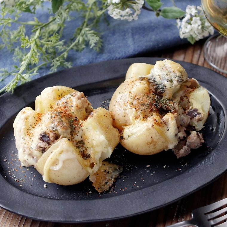 黒い楕円の皿に盛りつけられたサバ缶のやみつきチーズポテト