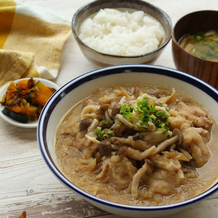 青い縁どりのある丼に盛り付けられた鶏肉ときのこのみぞれ煮