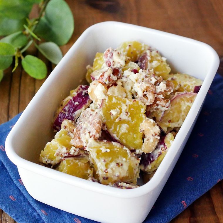 白い琺瑯の保存容器に入っているさつまいもメープルクリームチーズサラダ