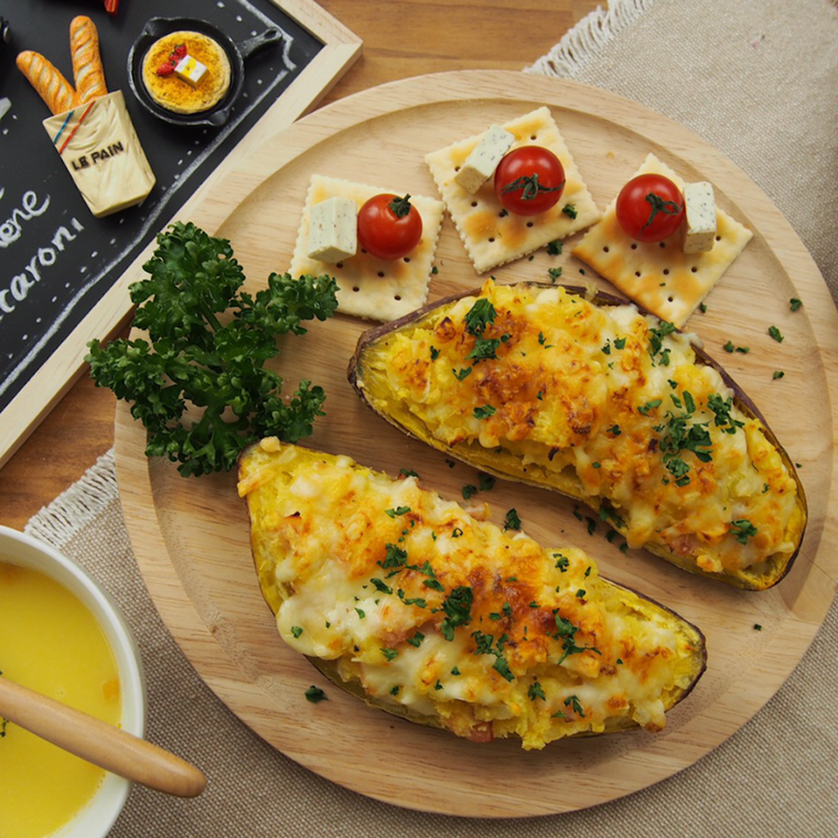 木の丸い皿にのせたさつまいものチーズグラタン