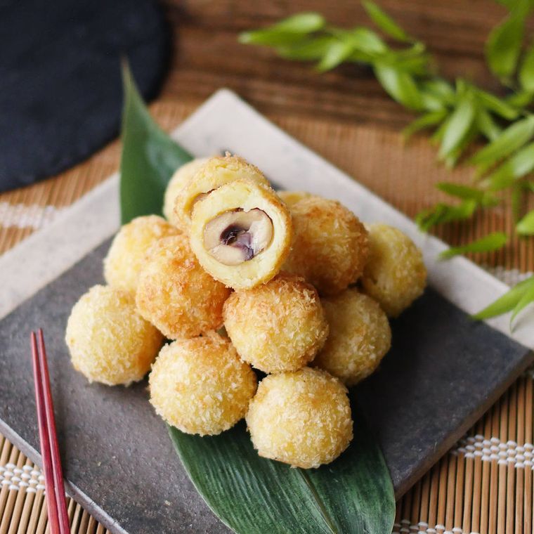 黒色の四角の小皿に盛り付けられているさつまいもと甘栗サプライズコロッケ