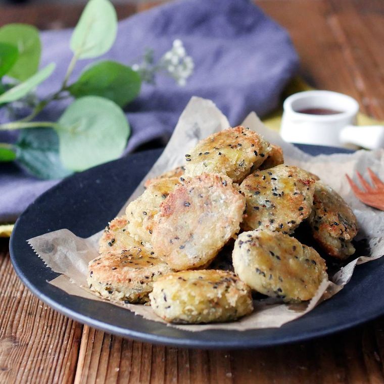 黒い円形の皿に盛り付けられている豆腐とさつまいものナゲット