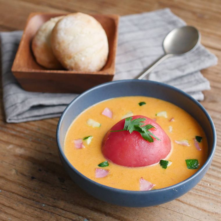 グレーの器に盛り付けた丸ごとトマトのクリームスープ