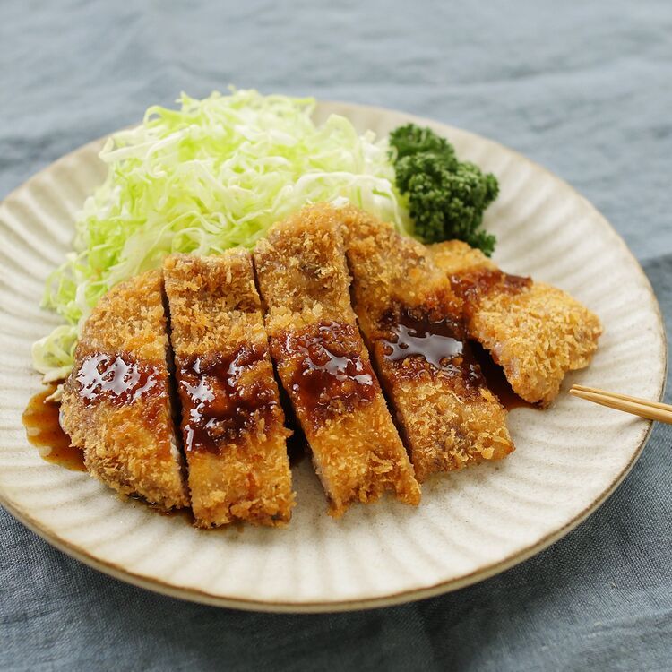 ベージュの皿に盛られたジューシーとんかつ
