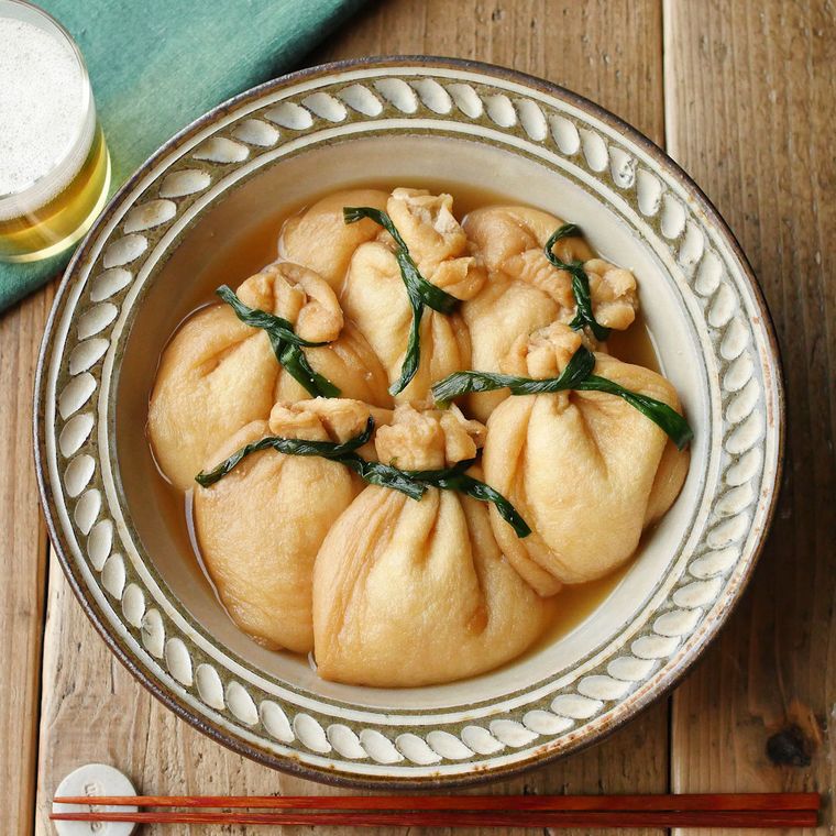 ベージュの皿に盛り付けられた明太チーズソースの餅巾着