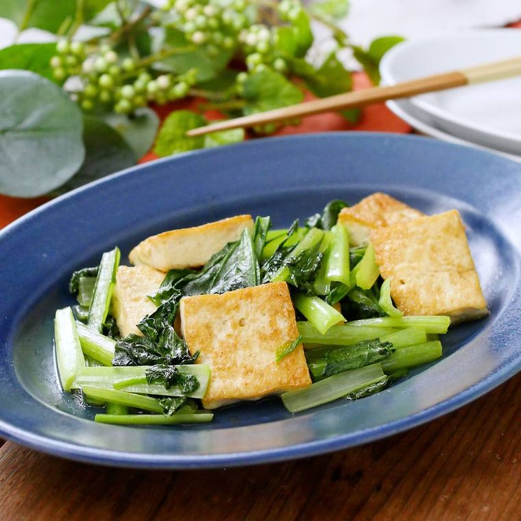 青いオーバル皿に盛り付けされた、木綿豆腐と小松菜の中華炒め