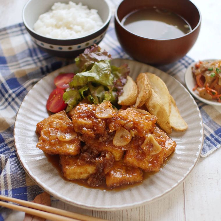 しのぎ皿に盛られた、豆腐のサイコロステーキにんにくソース