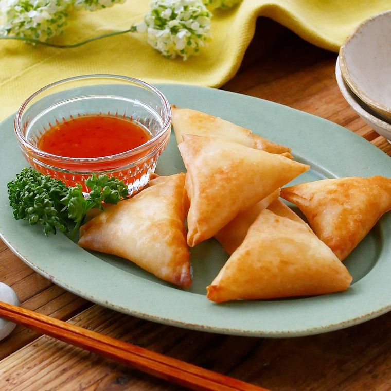 青い皿に盛られ、チリソースとパセリを添えたえびはんぺんの春巻き