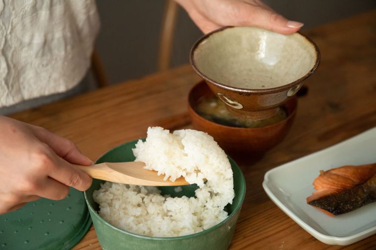 ご飯が入った9°の器からお茶碗によそっている写真