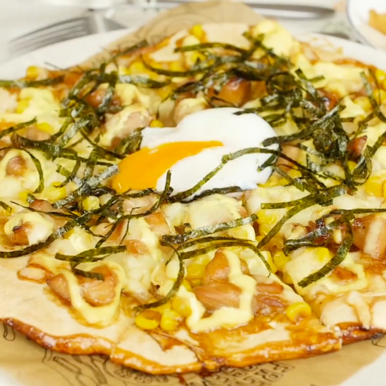 皿に盛られた温泉卵のせ照り焼きチキンマヨピザ