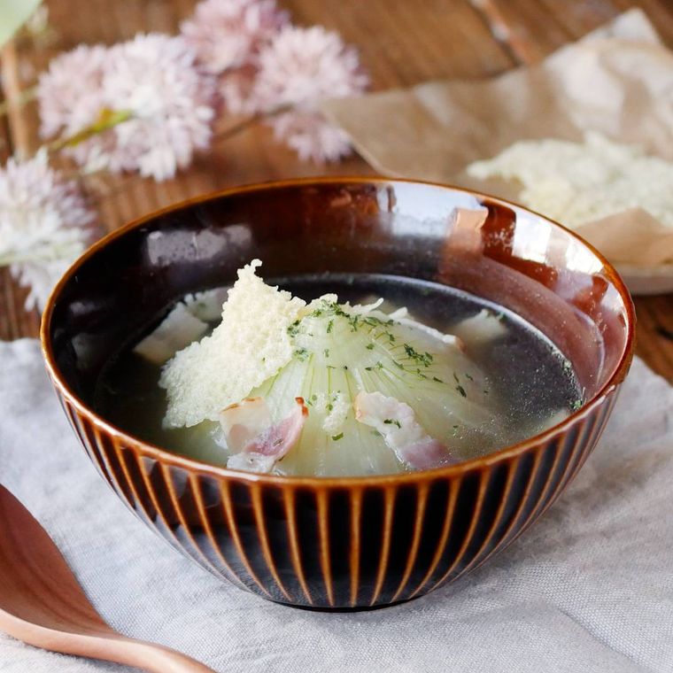 濃い茶色の椀に入った新玉ねぎの丸ごとスープ