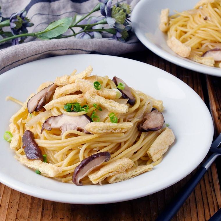 白い丸皿に盛り付けたしいたけと油揚げの和風パスタ