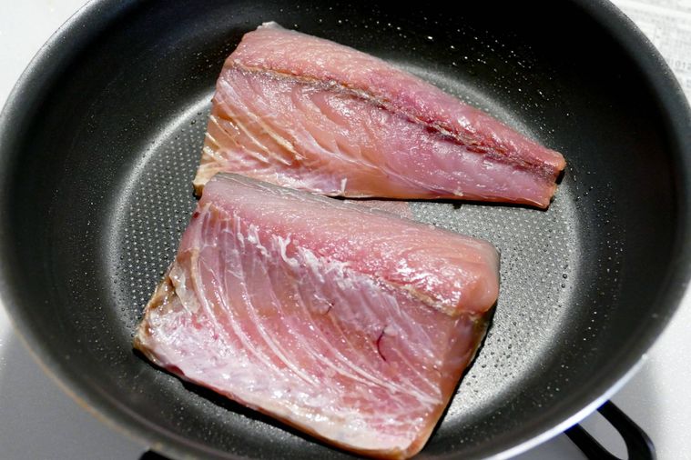 さばの皮目を下にしてフライパンで焼く様子