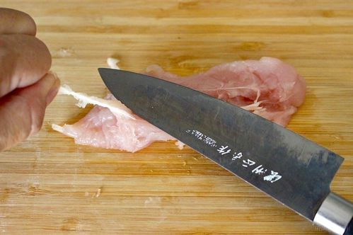 包丁の背面でささみの筋を取っている様子