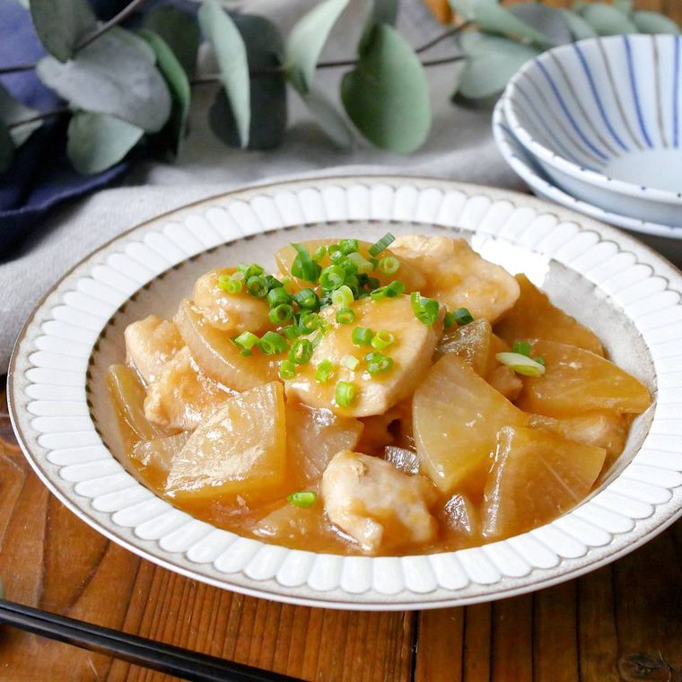 白い丸皿に盛った鶏肉と大根の煮物
