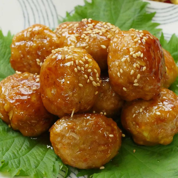 模様が入った白色の四角の皿に盛られたレンコンの甘酢だれミートボール