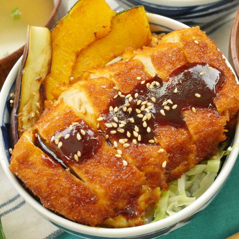 白い器に盛り付けられた豆腐カツ丼とナスとカボチャの素揚げ