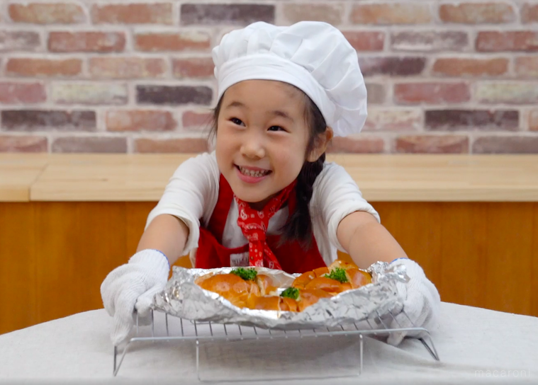 オーブンで焼き終わったロールパンと子どもシェフ