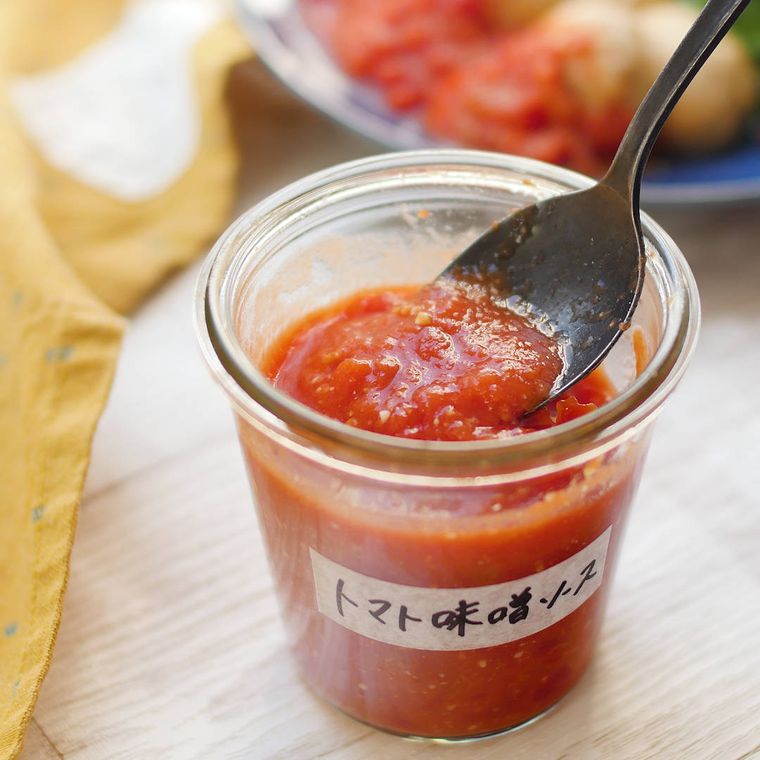 透明な瓶に入ったみそトマトソースを、スプーンですくっている様子