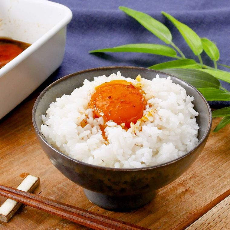 茶碗によそったごはんに卵黄のピリ辛漬けをのせたところ