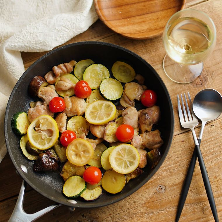 黒い皿に盛り付けられた鶏もも肉と彩り野菜のレモン炒め