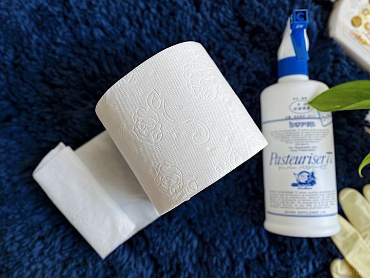 コストコのトイレットペーパーを、掃除道具や手袋と一緒に紺色のマットの上に置いたところ