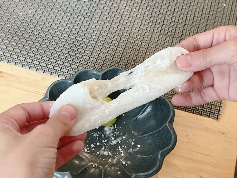 コストコのシャインマスカット大福を手で伸ばしている様子