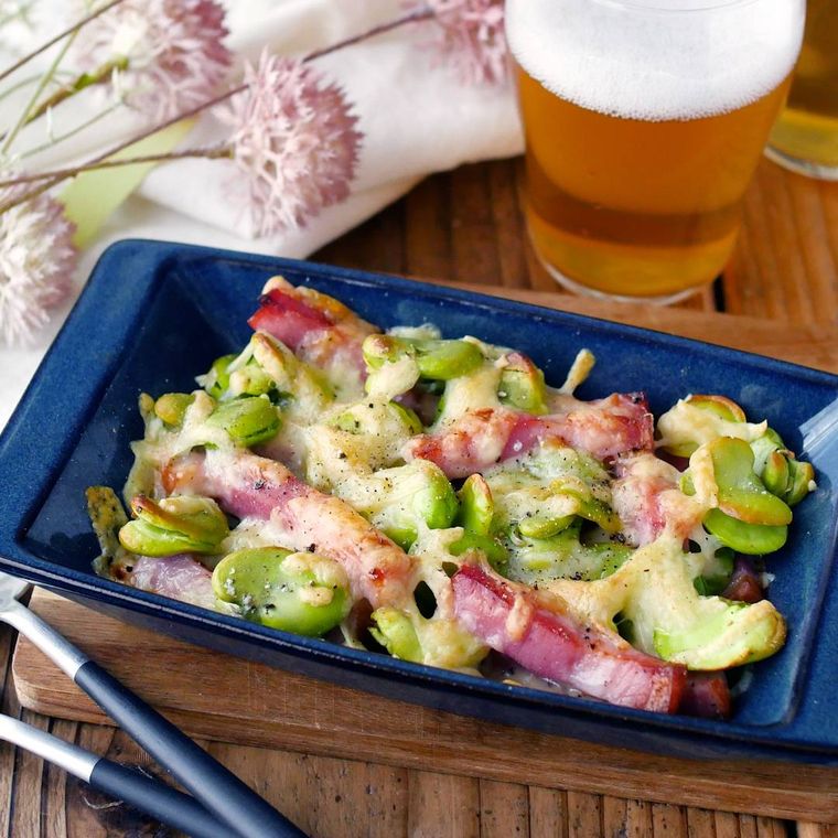 青色の四角のグラタン皿で焼かれたそらまめとベーコンのチーズ焼き