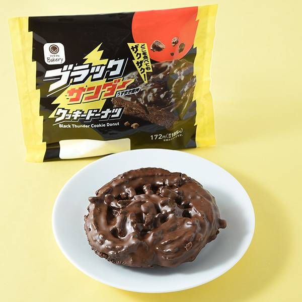 お皿にのせたファミリーマートのパン「ブラックサンダー クッキードーナツ」とパッケージ