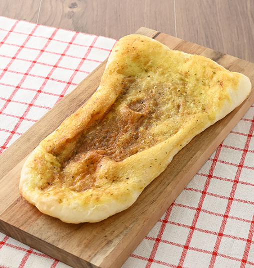 木製ボードにのせたファミマのパンどかっと満足パンバターチキンカレーナン