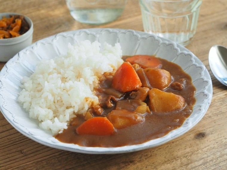 白いお皿に盛られたカレー、福神漬けとグラスに注がれた水